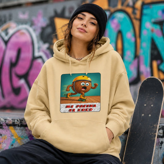 Mujer con sudadera amarilla con capucha Me Patina el Coco, diseño de coco patinador